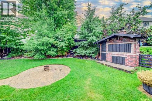 Spacious backyard featuring a wood fired brick oven, a dedicated fire pit area with stamped concrete pavers, and mature trees providing natural privacy - 521 Snowdrop Court, Kitchener, ON - Outdoor