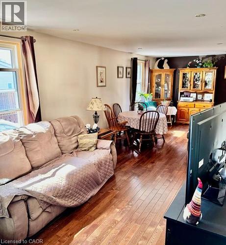 Hardwood-finish flooring throughout, featuring neutral wall tones and ample natural light from multiple windows - 342 Barton Street, Hamilton, ON - Indoor Photo Showing Living Room