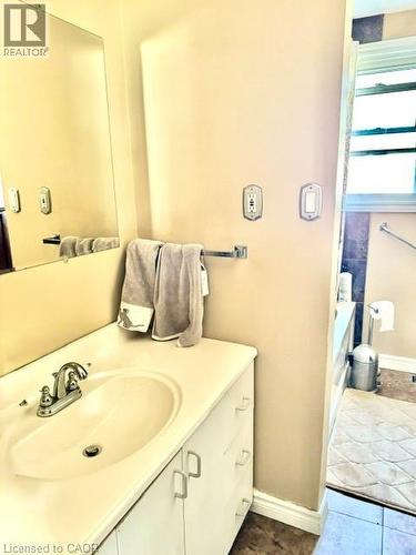 White vanity with an integrated sink and chrome faucet - 342 Barton Street, Hamilton, ON - Indoor Photo Showing Bathroom
