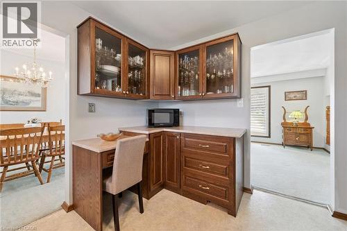 Built-in corner cabinetry with glass-front upper cabinets and a dedicated desk space featuring a light-toned countertop - 18 Strathcona Crescent, Kitchener, ON - Indoor Photo Showing Office