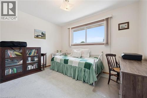 White wall interior with light gray carpeting, featuring a large window - 18 Strathcona Crescent, Kitchener, ON - Indoor Photo Showing Bedroom