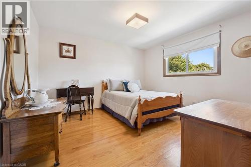 Spacious bedroom showcasing warm hardwood flooring and an abundance of natural light from a large window. - 18 Strathcona Crescent, Kitchener, ON - Indoor Photo Showing Bedroom