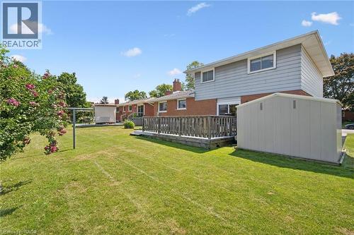 Spacious backyard oasis featuring a manicured lawn, mature landscaping, and detached storage shed - 18 Strathcona Crescent, Kitchener, ON - Outdoor With Deck Patio Veranda