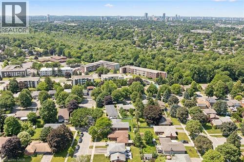 Aerial view showcasing this established residential neighborhood featuring mature tree-lined streets, single-family homes with varied architectural styles, and abundant green space - 18 Strathcona Crescent, Kitchener, ON - Outdoor With View