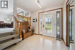 Foyer featuring a decorative glass front door with coordinating sidelights, light-toned tiled flooring, and a mirrored closet - 