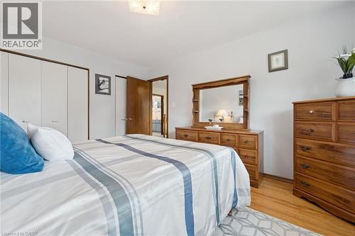 Spacious primary bedroom featuring hardwood flooring, ample natural light, and abundant storage. - 18 Strathcona Crescent, Kitchener, ON - Indoor Photo Showing Bedroom