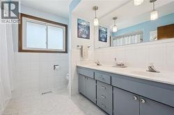 Double vanity with gray cabinetry and integrated sinks, complemented by a large wall-mounted mirror - 