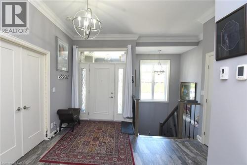 Welcoming foyer featuring a geometric pendant light fixture, neutral paint palette, and wood-finish flooring - 10 Craddock Boulevard, Jarvis, ON - Indoor Photo Showing Other Room