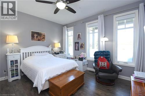 Bright bedroom with soft gray walls, white painted bed frame, and hardwood flooring - 10 Craddock Boulevard, Jarvis, ON - Indoor Photo Showing Bedroom