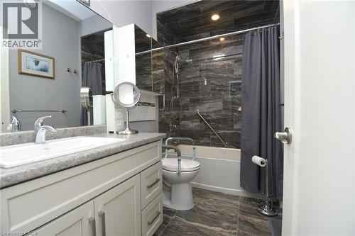 Spa-inspired bathroom featuring a floating vanity with stone countertop, chrome vessel sink, and polished chrome faucet - 10 Craddock Boulevard, Jarvis, ON - Indoor Photo Showing Bathroom
