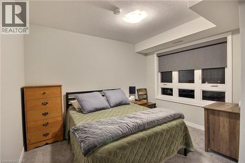 Carpeted room featuring a large window with roller shades, white trim, and a flush-mount ceiling light - 287 Chapel Hill Drive, Kitchener, ON - Indoor Photo Showing Bedroom