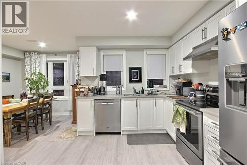 Modern kitchen featuring white cabinetry with ample storage, stainless steel appliances including a built-in refrigerator and wall oven, quartz countertops, a central island with integrated dishwasher - 287 Chapel Hill Drive, Kitchener, ON - Indoor Photo Showing Kitchen