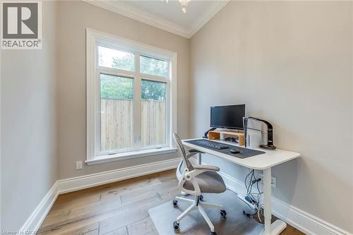 Room featuring wood-finish flooring, a double-paned window with bright white trim, neutral wall paint, white baseboards, and crown molding - 436 Willis Drive, Oakville, ON - Indoor Photo Showing Office