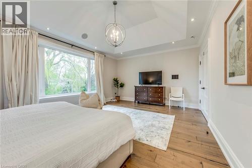 Spacious room featuring a vaulted ceiling, wood-finish flooring, a contemporary chandelier, recessed lighting, and a large window - 436 Willis Drive, Oakville, ON - Indoor Photo Showing Bedroom