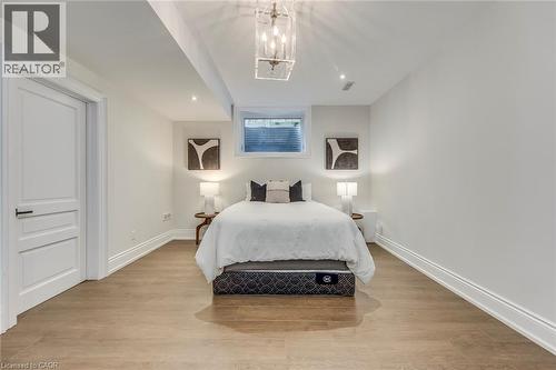 Recessed lighting illuminating wood-finish flooring, white trim, and a window with a metal grate - 436 Willis Drive, Oakville, ON - Indoor Photo Showing Bedroom