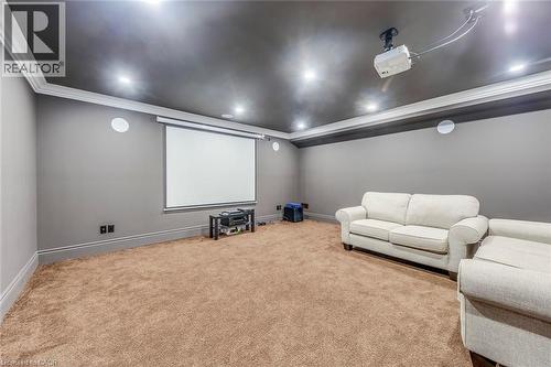 Dedicated media room featuring a large projector screen, ceiling-mounted projector, recessed lighting, crown molding, and plush carpeting - 436 Willis Drive, Oakville, ON - Indoor