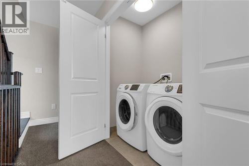 Dedicated laundry area with front-loading appliances, neutral wall paint, and overhead lighting - 2 Waterview Lane, Grimsby, ON - Indoor Photo Showing Laundry Room
