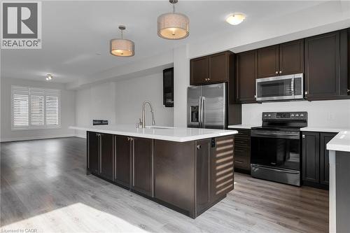 Modern kitchen featuring a large island with an integrated sink and gooseneck faucet - 2 Waterview Lane, Grimsby, ON - Indoor Photo Showing Kitchen
