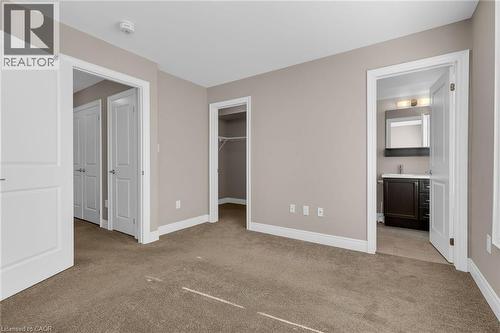 Neutral-toned bedroom featuring plush carpeting, white trim, and a built-in closet with shelving - 2 Waterview Lane, Grimsby, ON - Indoor Photo Showing Other Room
