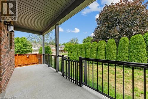 Expansive covered porch featuring a concrete surface, black aluminum railing, and brick exterior - 24 Knack Lane, Cambridge, ON - Outdoor With Deck Patio Veranda With Exterior