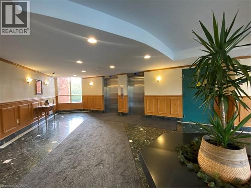 Lobby area featuring rich paneled wainscoting, polished stone flooring, recessed lighting, and wall sconces - 30 Blue Springs Drive Unit# Ph3, Waterloo, ON - Indoor Photo Showing Other Room