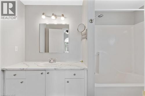 Bathroom featuring a white vanity with a single basin, a stone-finish countertop, and white cabinetry - 129 Kovac Road, Cambridge, ON - Indoor Photo Showing Bathroom