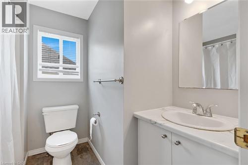 Bathroom featuring a white vanity with an undermount sink, a chrome faucet, and a wall-mounted mirror - 129 Kovac Road, Cambridge, ON - Indoor Photo Showing Bathroom