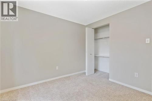 Neutral-toned carpeted room featuring a built-in closet with shelving and hanging rod - 129 Kovac Road, Cambridge, ON - Indoor Photo Showing Other Room