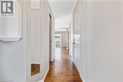 Hallway featuring wood-finish flooring, light grey painted walls, recessed lighting, and a decorative wall niche with a shelf - 129 Kovac Road, Cambridge, ON - Indoor Photo Showing Other Room