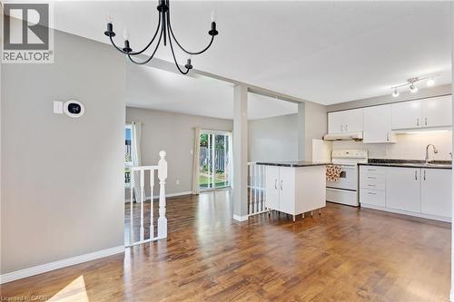 Kitchen featuring white cabinetry, contrasting dark countertops, and white appliances - 129 Kovac Road, Cambridge, ON - Indoor Photo Showing Kitchen