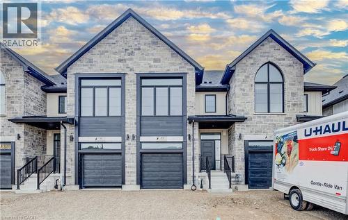 Stone facade townhome with multi-pane windows, black-framed entry doors, and attached garages - 89 Rivergreen Crescent, Cambridge, ON - Outdoor With Facade