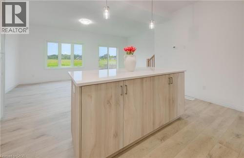 Kitchen island featuring wood-finish cabinetry and a light-toned countertop - 89 Rivergreen Crescent, Cambridge, ON - Indoor