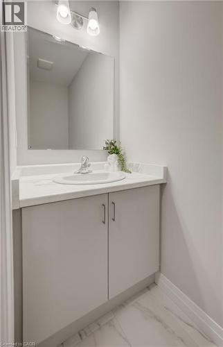 Bathroom vanity featuring a built-in sink, light-toned countertop, and dual-door cabinetry - 89 Rivergreen Crescent, Cambridge, ON - Indoor Photo Showing Bathroom