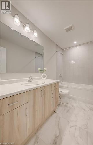 Bathroom featuring a light wood-finish vanity with an integrated sink, a white countertop, and a large mirror - 89 Rivergreen Crescent, Cambridge, ON - Indoor Photo Showing Bathroom