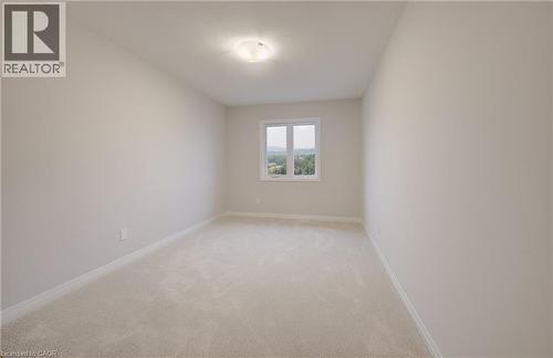 Bright room featuring neutral-toned carpeting and walls, a white trim package, and a window providing natural illumination - 89 Rivergreen Crescent, Cambridge, ON - Indoor Photo Showing Other Room