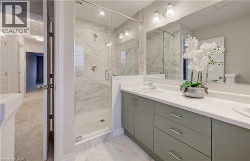 Spacious bathroom featuring a glass-enclosed shower with marble-look tile, a dual-sink vanity with light green cabinetry, and chrome fixtures - 89 Rivergreen Crescent, Cambridge, ON - Indoor Photo Showing Bathroom