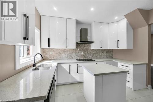 Contemporary kitchen featuring white cabinetry with black hardware, quartz countertops, and a tile-finish flooring - 334 Cannon Street E, Hamilton, ON - Indoor Photo Showing Kitchen With Upgraded Kitchen