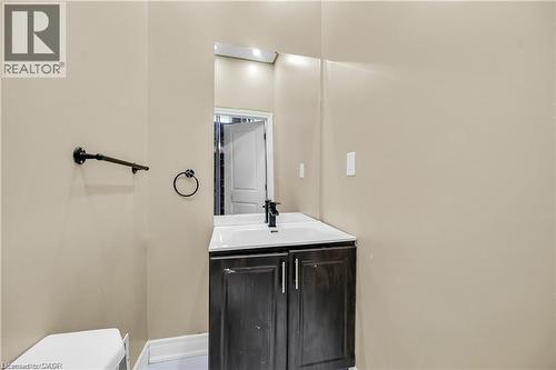 Vanity with dark wood-finish cabinetry, white countertop, and integrated sink - 334 Cannon Street E, Hamilton, ON - Indoor Photo Showing Bathroom