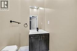 Vanity with dark wood-finish cabinetry, white countertop, and integrated sink - 
