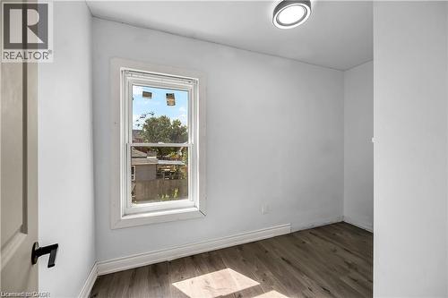 Bright secondary bedroom featuring a large casement window with white trim, wood-finish flooring, and recessed ceiling lighting - 334 Cannon Street E, Hamilton, ON - Indoor Photo Showing Other Room