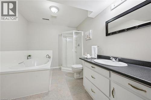 Bathroom featuring a corner soaking tub, separate glass-enclosed shower, and a vanity with an integrated sink - 187 Westchester Drive, Kitchener, ON - Indoor Photo Showing Bathroom