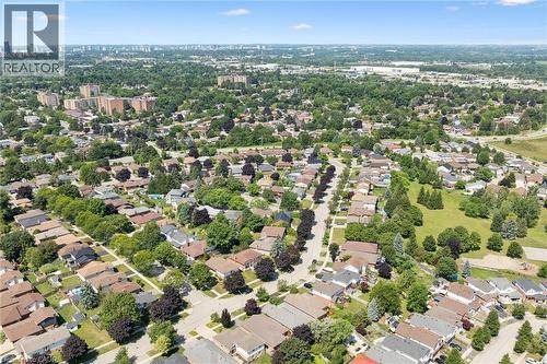 Expansive aerial encompassing a residential neighborhood with detached homes, mature tree coverage, clear skies, visible streets, and distant city structures - 187 Westchester Drive, Kitchener, ON - Outdoor With View