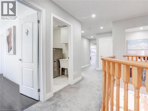 Hallway featuring light gray carpet, recessed lighting, white trim, and a natural wood staircase railing - 584 Pinery Trail, Waterloo, ON - Indoor Photo Showing Other Room
