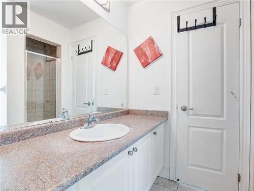 Bathroom vanity featuring a built-in sink, chrome faucet, and speckled countertop - 584 Pinery Trail, Waterloo, ON - Indoor Photo Showing Bathroom