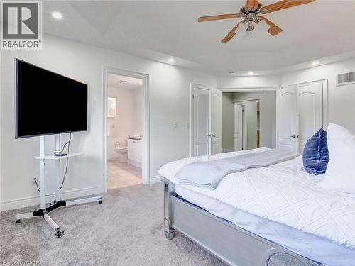 Carpeted interior space featuring recessed lighting, a ceiling fan with wood-finish blades, and white paneled doors - 584 Pinery Trail, Waterloo, ON - Indoor Photo Showing Bedroom