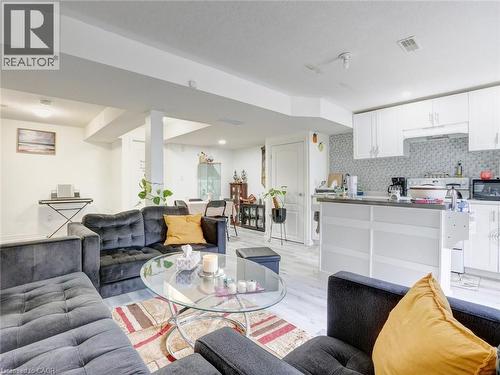 Open-concept living area featuring light wood-finish flooring, white walls, and recessed lighting - 584 Pinery Trail, Waterloo, ON - Indoor