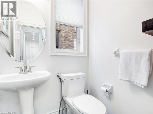 Pedestal sink with brushed nickel faucet, oval wall mirror, and privacy window with pleated blinds - 584 Pinery Trail, Waterloo, ON - Indoor Photo Showing Bathroom