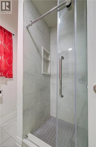Glass-enclosed shower featuring large format wall tiles, a recessed shelf, and a tiled shower pan - 182 Avalon Place, Kitchener, ON - Indoor Photo Showing Bathroom