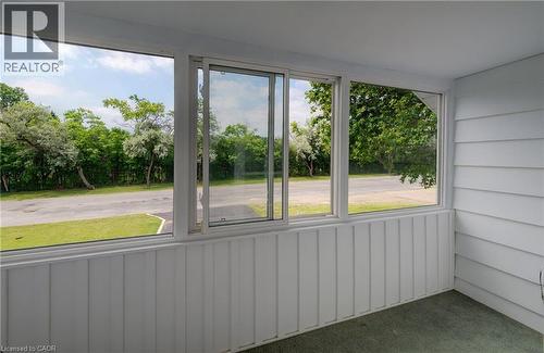 Enclosed sunroom featuring multiple windows, a sliding glass panel, white vertical paneling, and white horizontal siding - 182 Avalon Place, Kitchener, ON -  Photo Showing Other Room