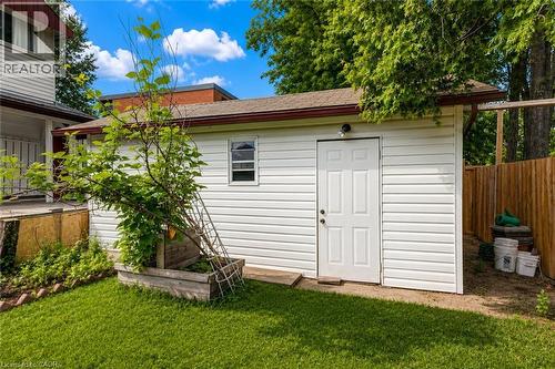 Detached outbuilding with white vinyl siding, a brown shingle roof, and a panel-style entry door - 182 Avalon Place, Kitchener, ON - Outdoor With Exterior